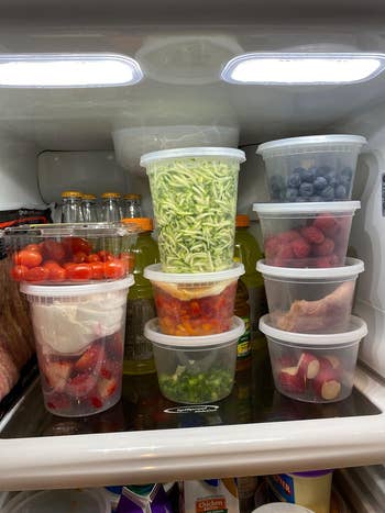 reviewer's interior of fridge with deli containers holding assorted foods