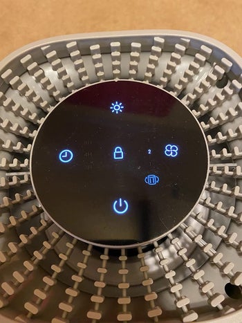 Reviewer image of close up of top of product with black light up touchscreen