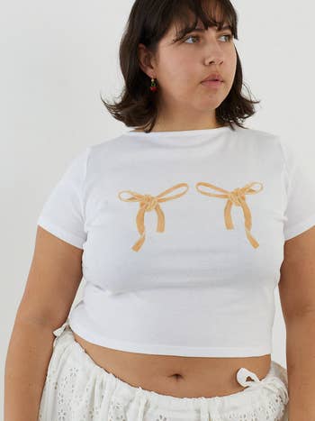 model in a white cropped tee with two pasta bows on it 