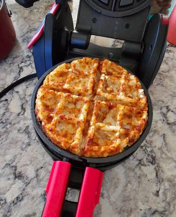 reviewer's waffle in the maker with crispy texture in a waffle maker on a countertop, ready to be served