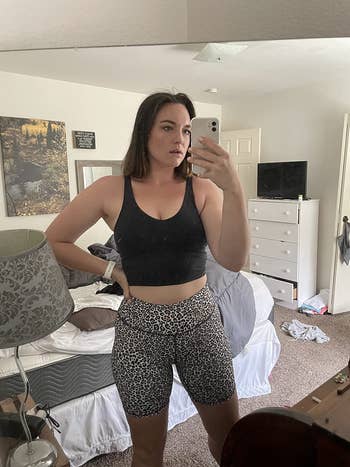 reviewer mirror selfie wearing black crop tank top and leopard print leggings