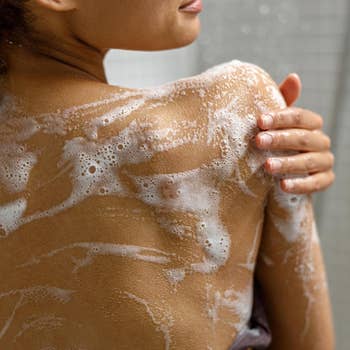 Person washing their shoulder with soap