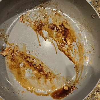 Dirty cooking pan with leftover sauce and food residue