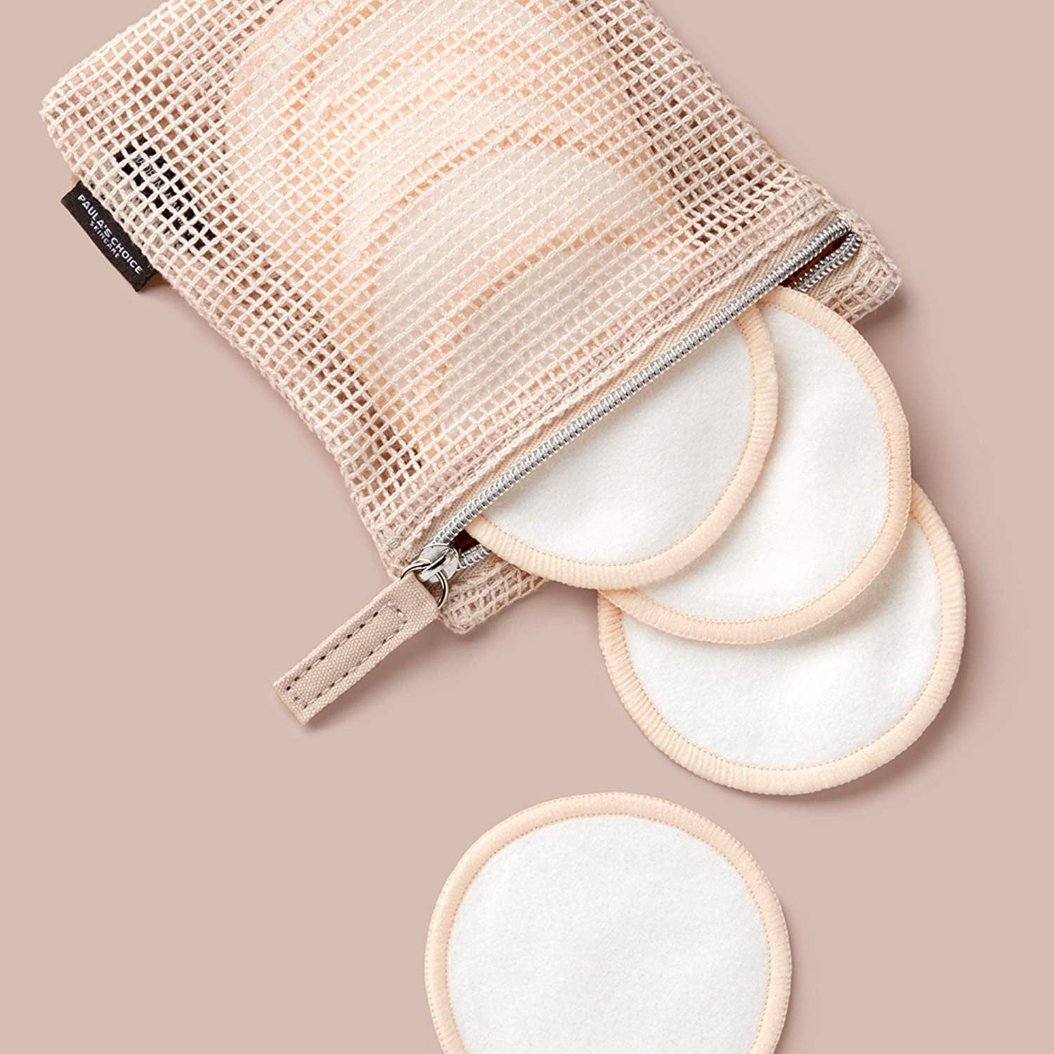 several reusable cotton pads coming out of its mesh bag
