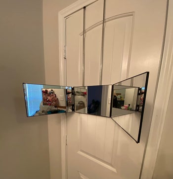 reviewer photo of the mirror open and hanging from a door frame