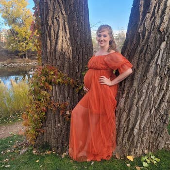 reviewer posing in orange tulle tiered maxi dress