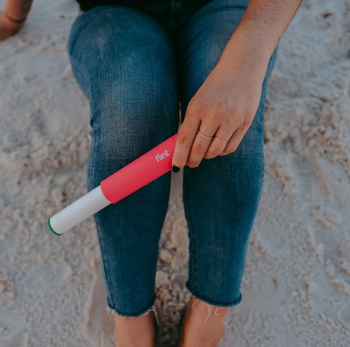 model using the pink lint roller to get sand off their jeans