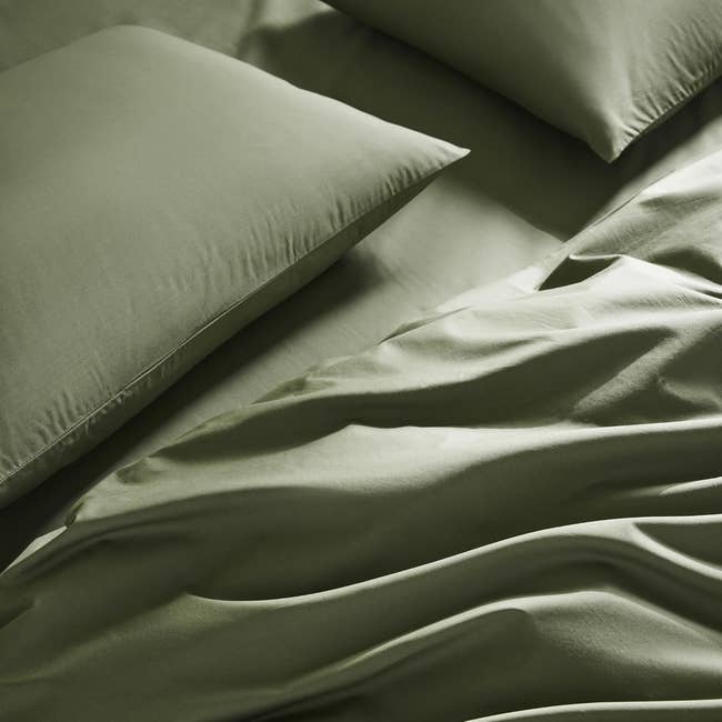 Smooth, luxurious satin bed sheets and pillowcases shown on a neatly made bed