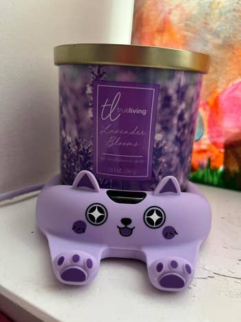 A lavender-scented candle connected  purple cat