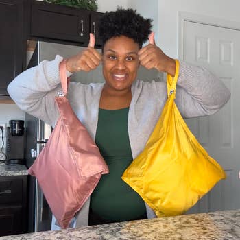 a reviewer holding two wet bags with the attached wrist straps