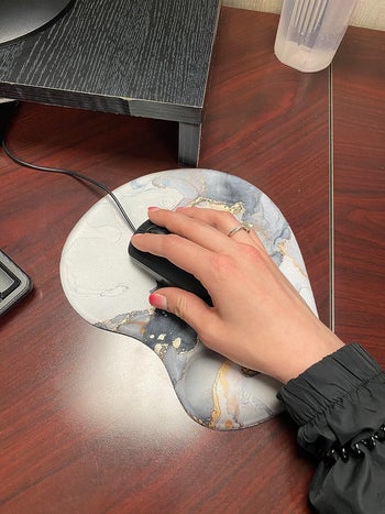 reviewer using marble printed mouse pad