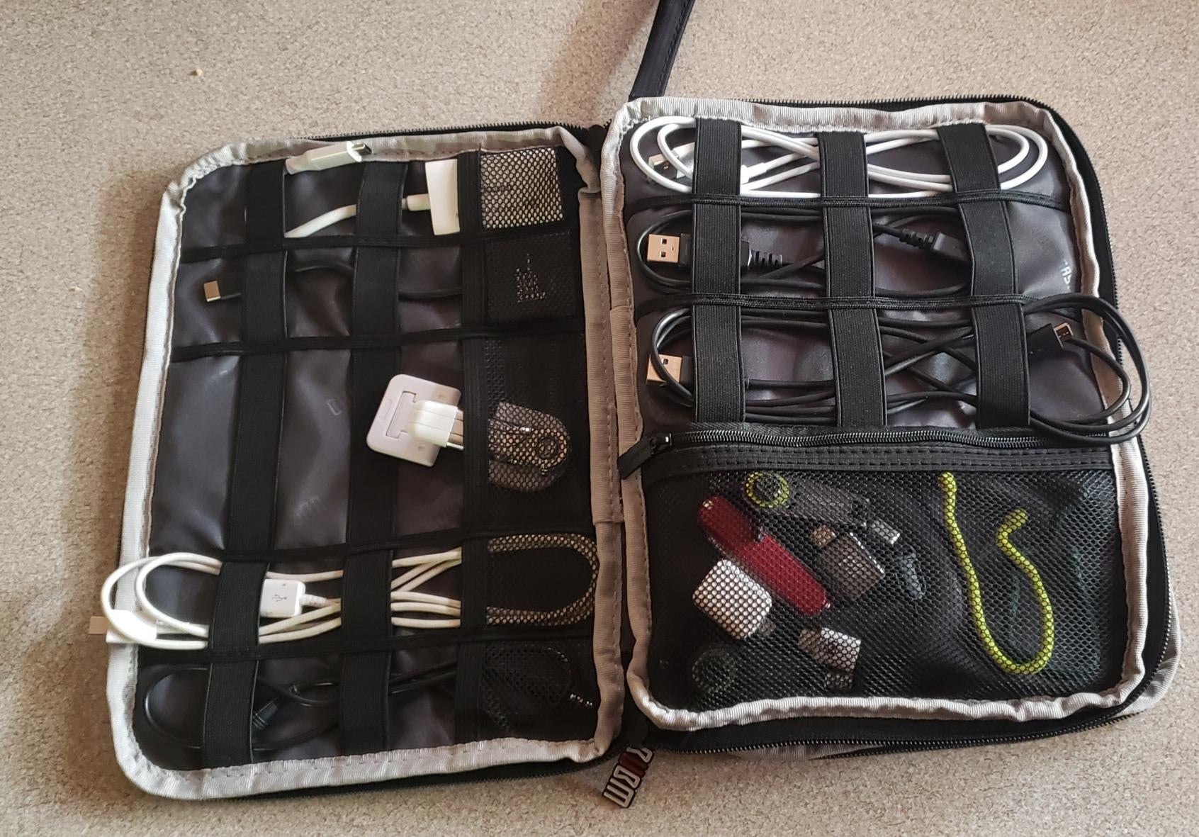 reviewer image of the the rectangle organizer open showing the three layers with different spots of electronics and cords