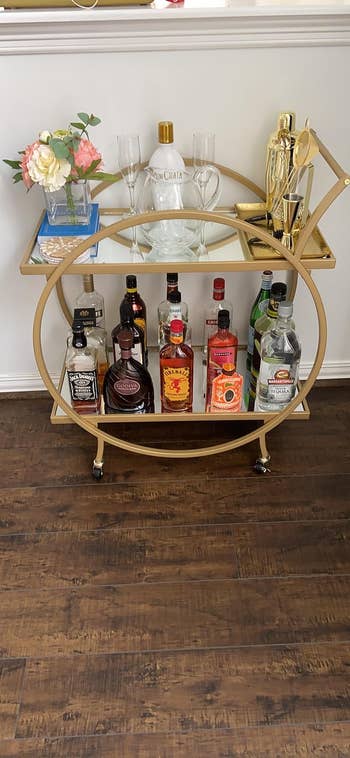 reviewers bar cart with a gold frame filled with liquor and glasses
