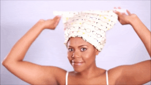 Gif of a model using the velcro straps to close the shower cap