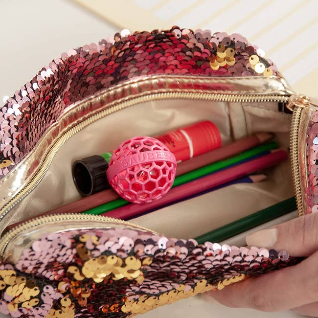 a pink sequin bag open to show the pink ball
