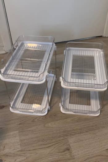 Two wide integrative stackable retention bins connected a woody floor, designed for organizing household items