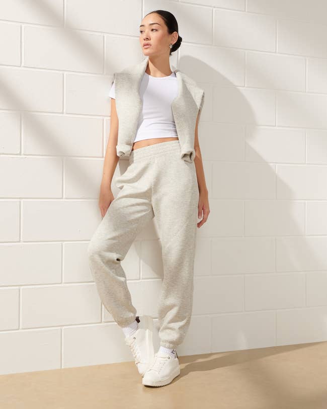 model wearing light gray sweatpants with a cropped white T-shirt