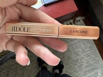 Person holds Lancôme Lash Idôle mascara successful  a rose-gold conduit  labeled 