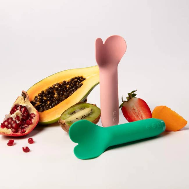 Pink and green bullet vibrators surrounded by fruits