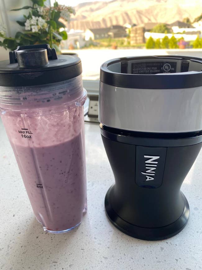 a smoothie cup beside the ninja blender