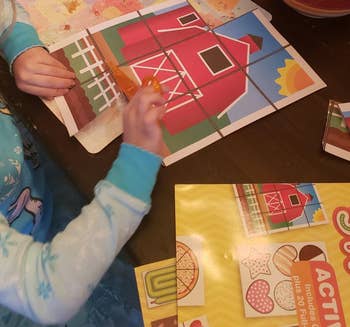child cutting out farmhouse picture with scissors