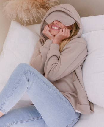 Model wearing the tan sweater with the eye mask down