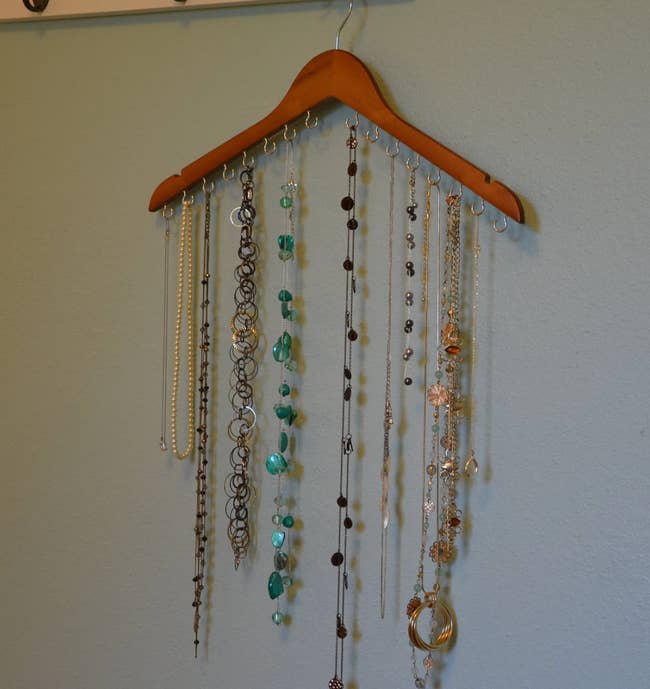 A hanger with 16 hooks holding various necklaces