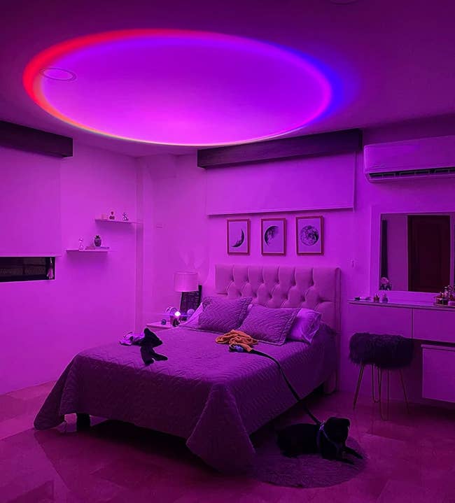 reviewer using the lamp in their bedroom to create purple, blue, and red light