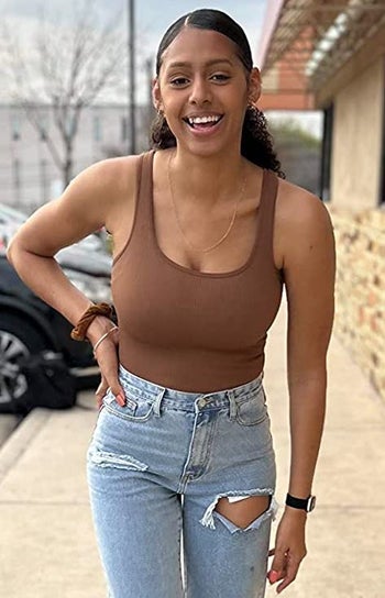reviewer wearing the brown bodysuit with jeans