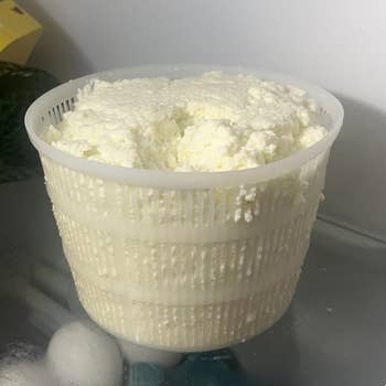 Container of caller ricotta food connected a solid support successful a refrigerator adjacent to eggs and a box