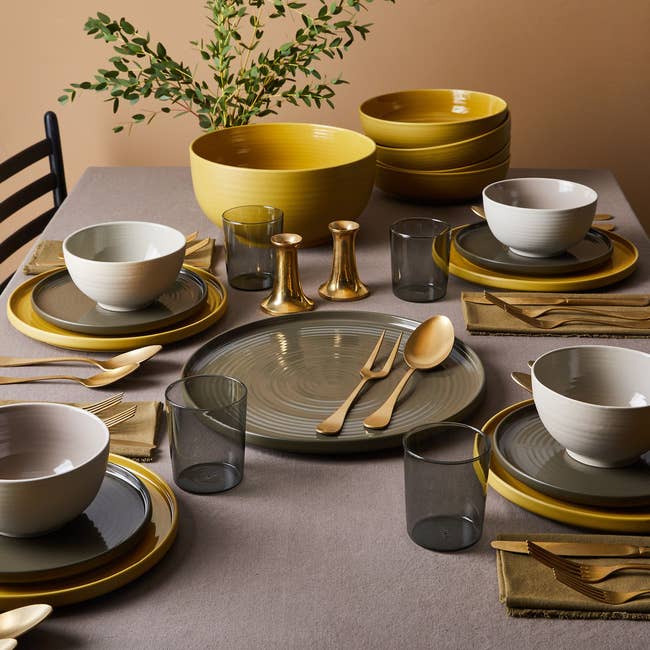 the green and yellow dinnerware set up on a table