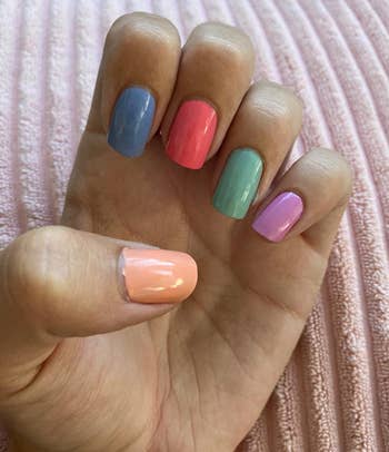 reviewer's hand showing a different color on each nail