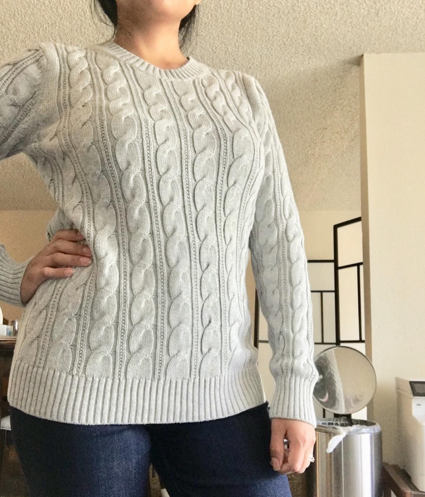 Reviewer is wearing an off-white cable knit sweater and jeans