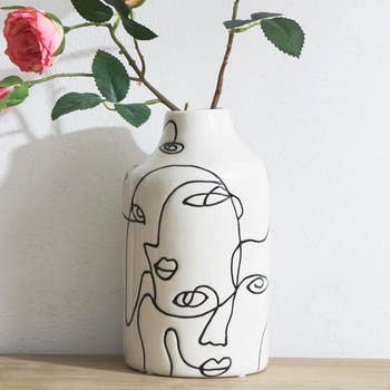 Decorative vase with abstract face line art, used for home decor shopping