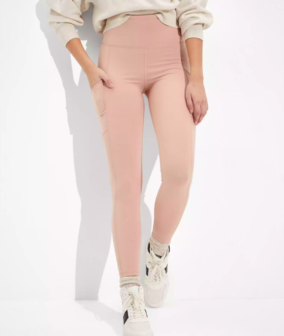 Model is wearing light pink leggings with white sneakers