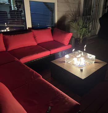 another reviewer's patio setup at night with red sectional sofa and active fire pit table