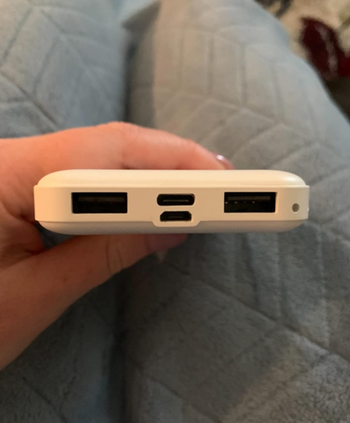 reviewer showing ports for charging available on power bank