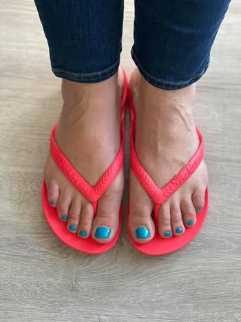 Person wearing flip-flops connected a woody floor, showcasing a comfortable, casual benignant cleanable for summertime shopping
