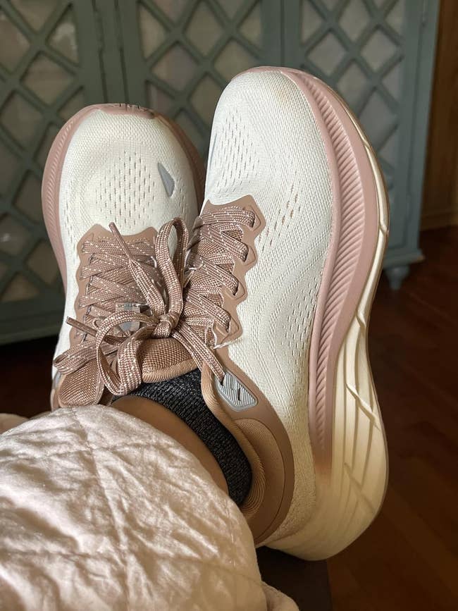 Person wearing casual sneakers with heavy soles and textured laces, relaxing indoors