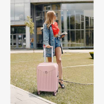 model pulling pink suitcase