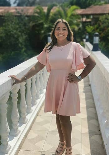 reviewer wearing the light pink dress with sandals