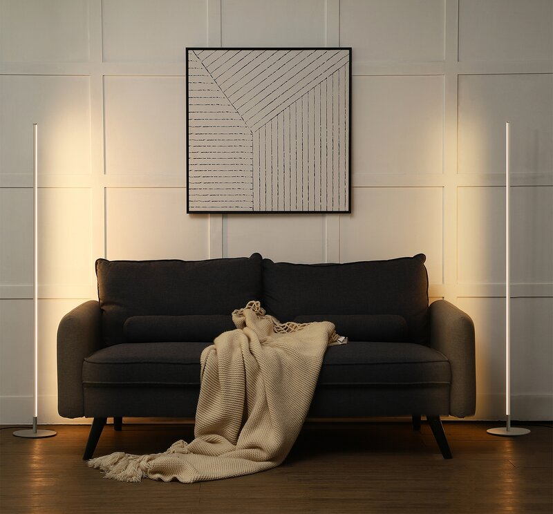 the two column lamps one on each side of a charcoal gray couch