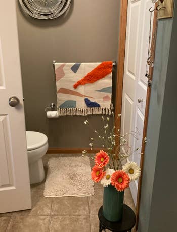 reviewer's rug used as wall hanging in bathroom 