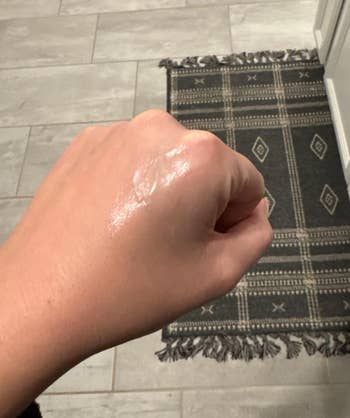 Person making use of a dollop of sure gel on the again of their hand