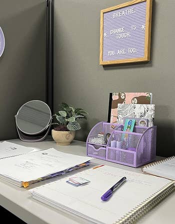 a purple felt letterboard hung in a reviewer's desk setup