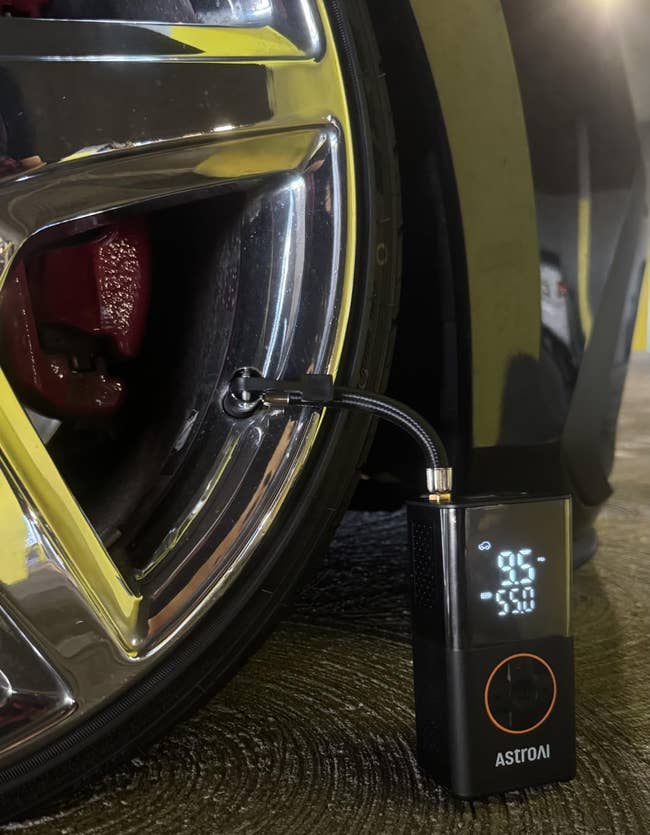 Portable tyre inflator connected to a car tire, displaying unit astatine 9.5 PSI