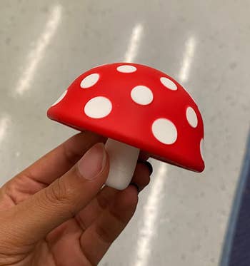 Reviewer holding small silicone mushroom shaped object 