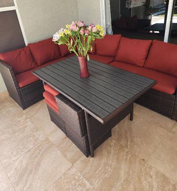 another reviewer's red dining sectional with three ottoman chairs on a deck