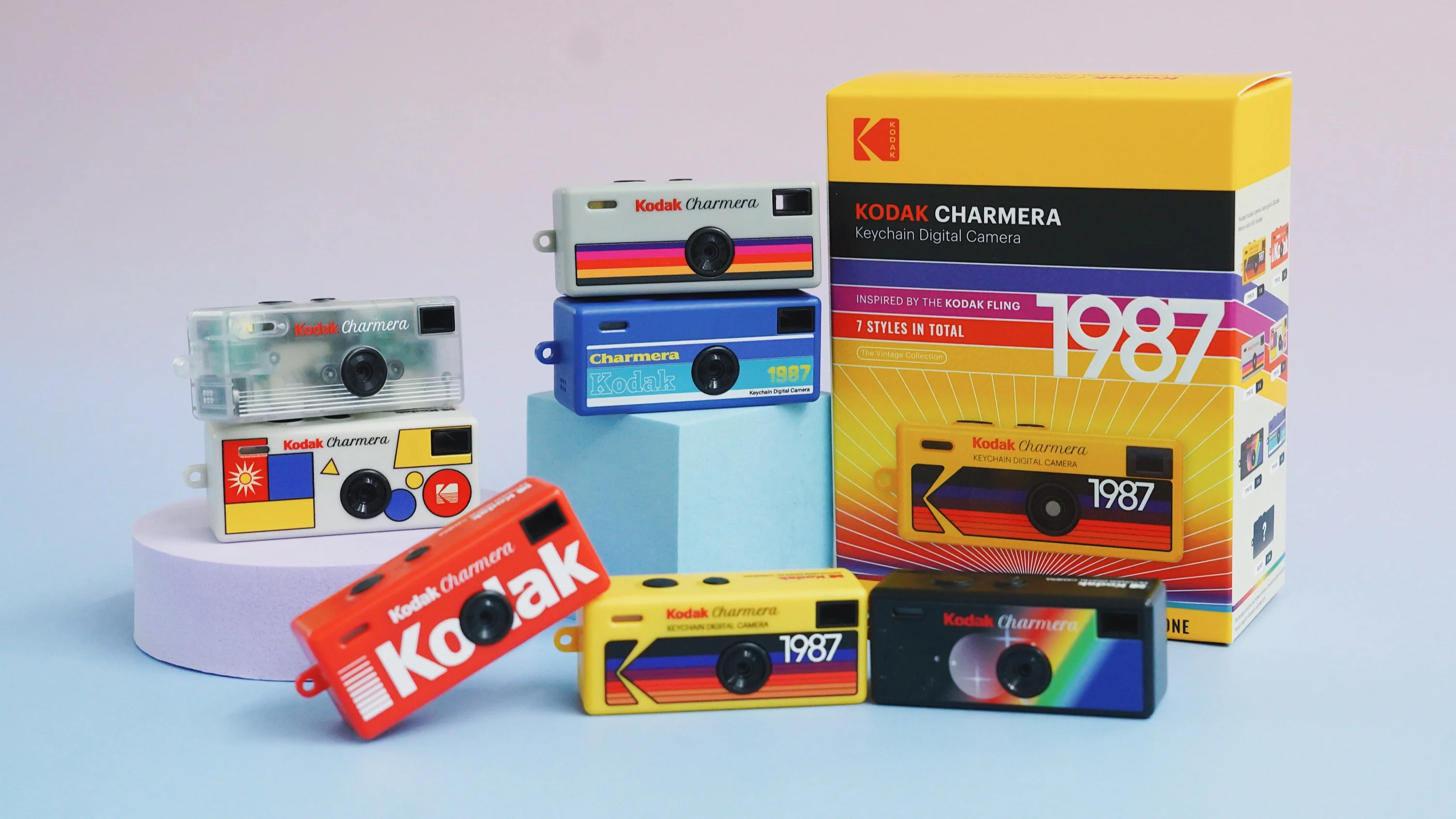 Keychain digital cameras in retro styles and colors displayed with a Kodak box, highlighting a nostalgic design for shoppers