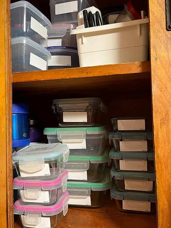 A reviewer shows their cabinet full of containers with labeled items